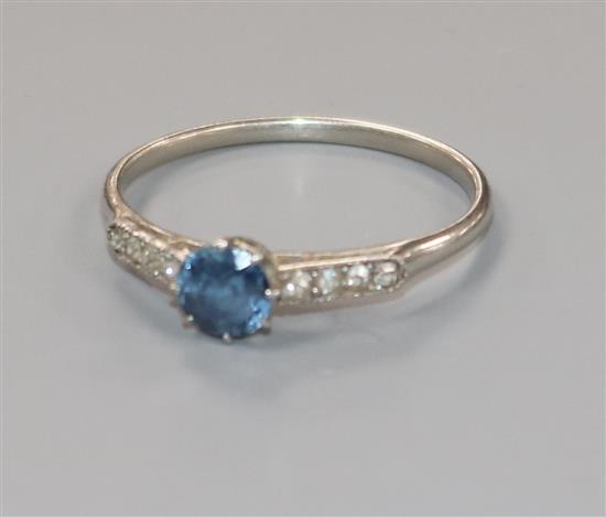 An early/mid 20th century white metal, single stone sapphire ring with diamond set shoulders, size O/P.